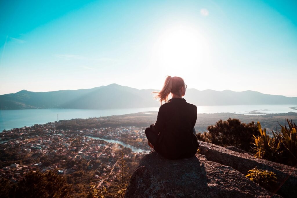 A person enjoying a tranquil mountain view at sunset, reflecting solitude.