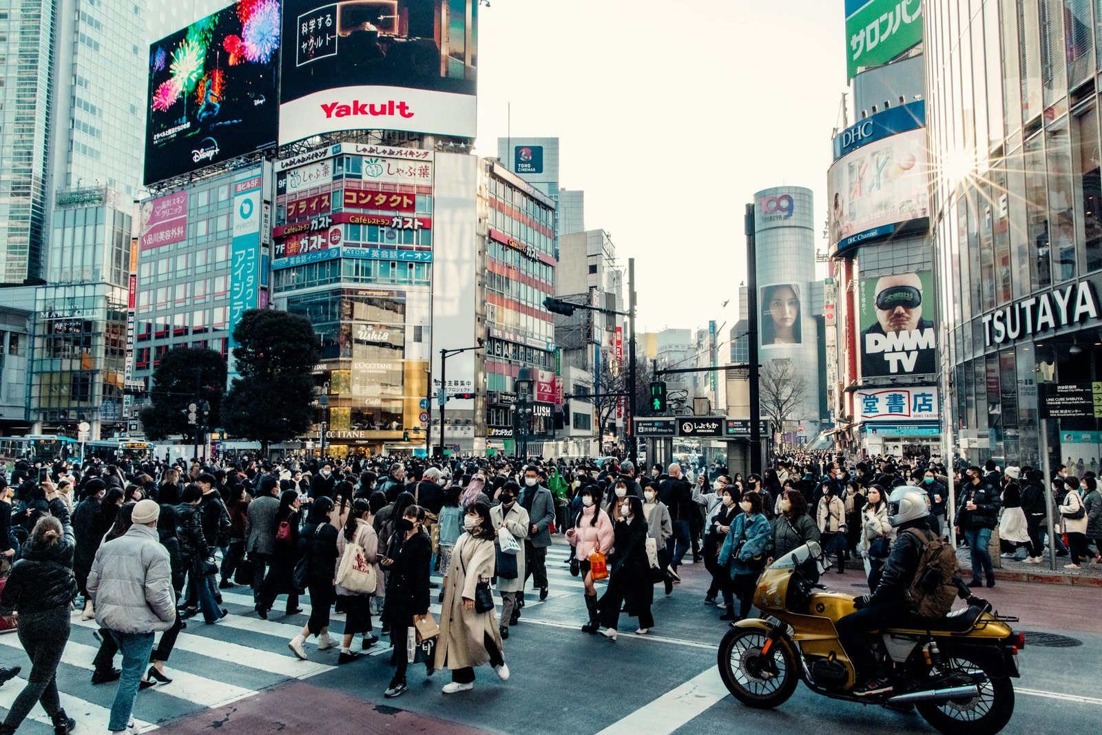 Vibrant daytime scene at Shibuya Crossing, Tokyo, with a crowd of people.